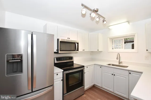 a kitchen with white cabinets and stainless steel appliances