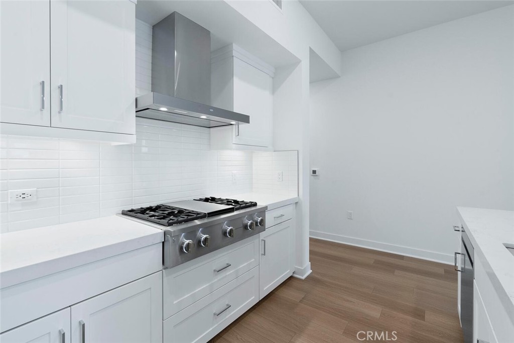 1306 Rivington Irvine, CA 92612 - Photo 13 of 75 a kitchen with granite countertop white cabinets and white stove
