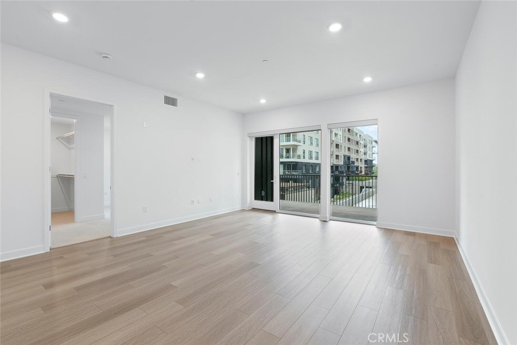 1306 Rivington Irvine, CA 92612 - Photo 4 of 75 a view of an empty room with wooden floor and a window