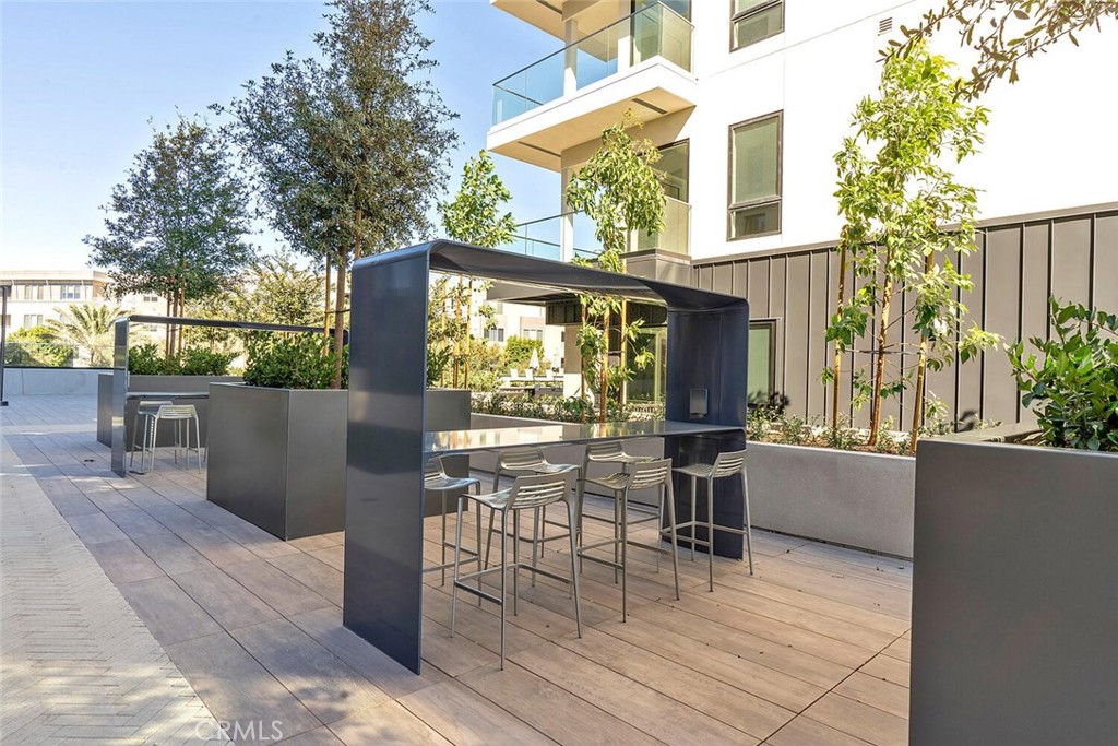 1306 Rivington Irvine, CA 92612 - Photo 47 of 75 a view of a patio with table and chairs and potted plants with wooden floor and fence