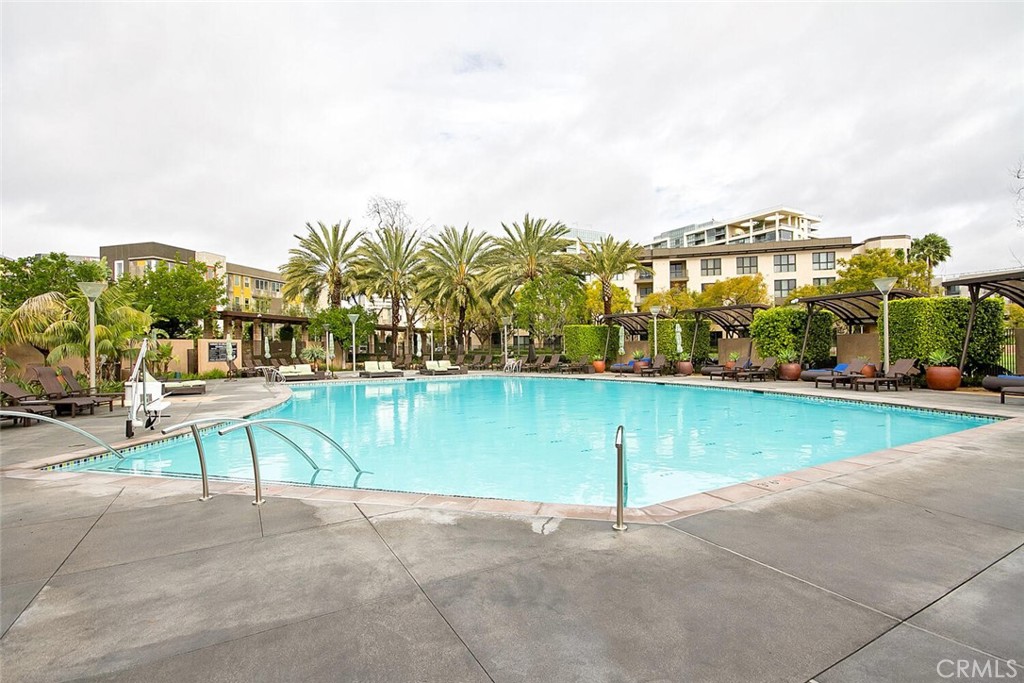 1306 Rivington Irvine, CA 92612 - Photo 59 of 75 a view of a swimming pool with a lawn chairs under an umbrella