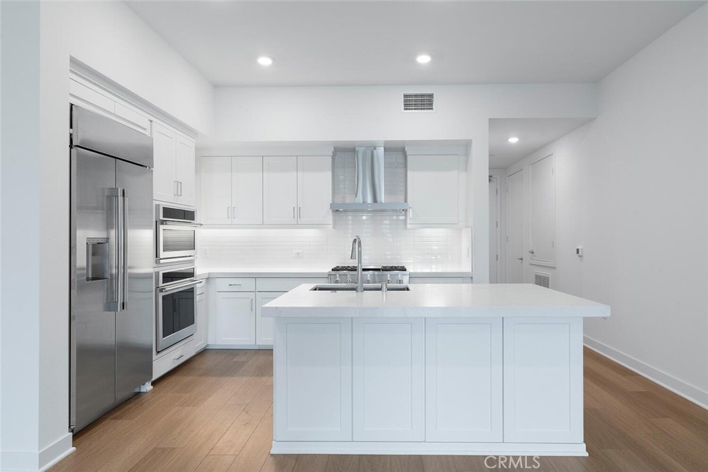 1306 Rivington Irvine, CA 92612 - Photo 7 of 75 a kitchen with kitchen island a sink stainless steel appliances and cabinets