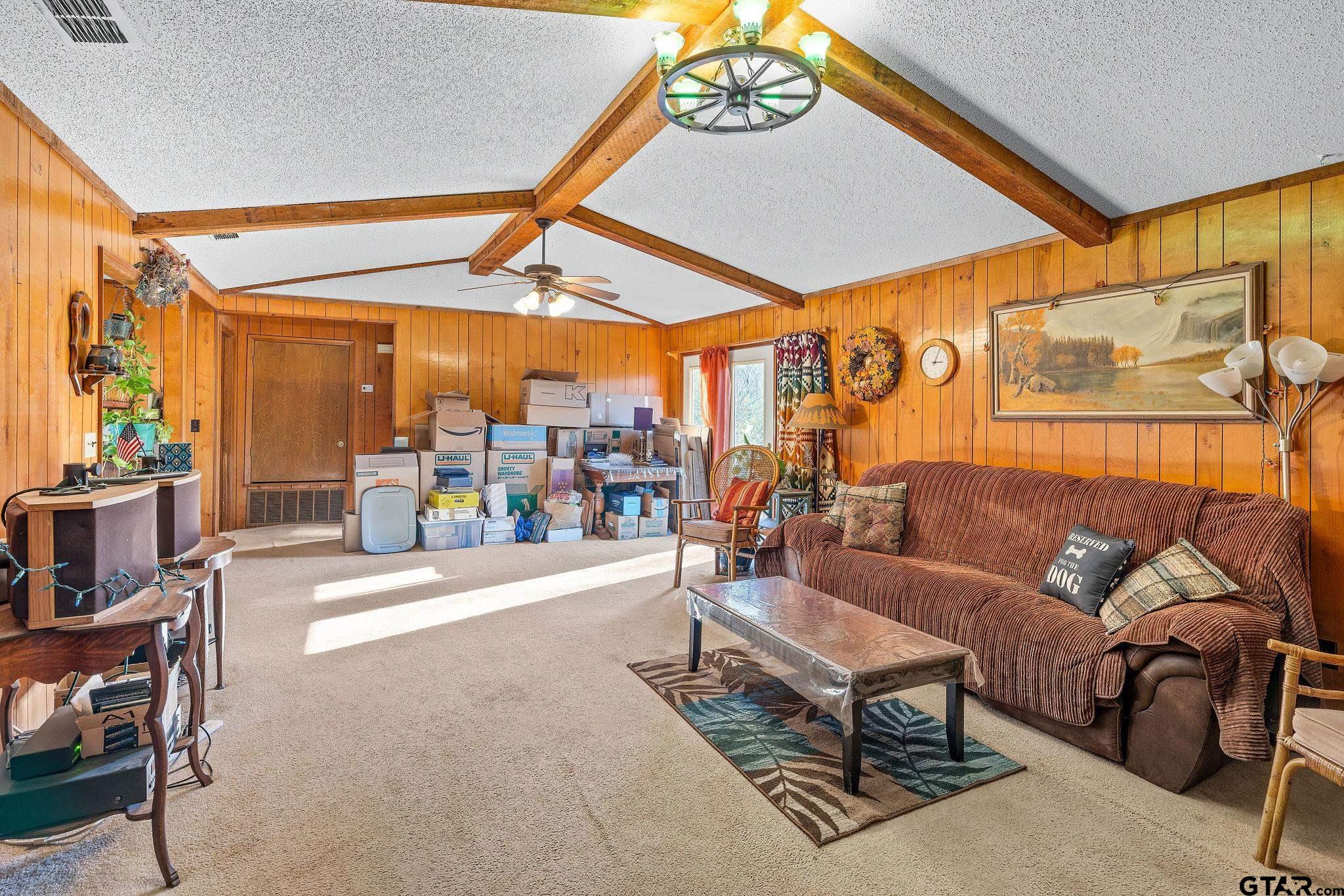 8439 Hyena Road Gilmer, TX 75644 - Photo 3 of 16 a living room with furniture a chandelier and a large window