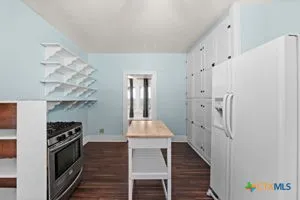 a kitchen with stainless steel appliances a stove top oven and a refrigerator
