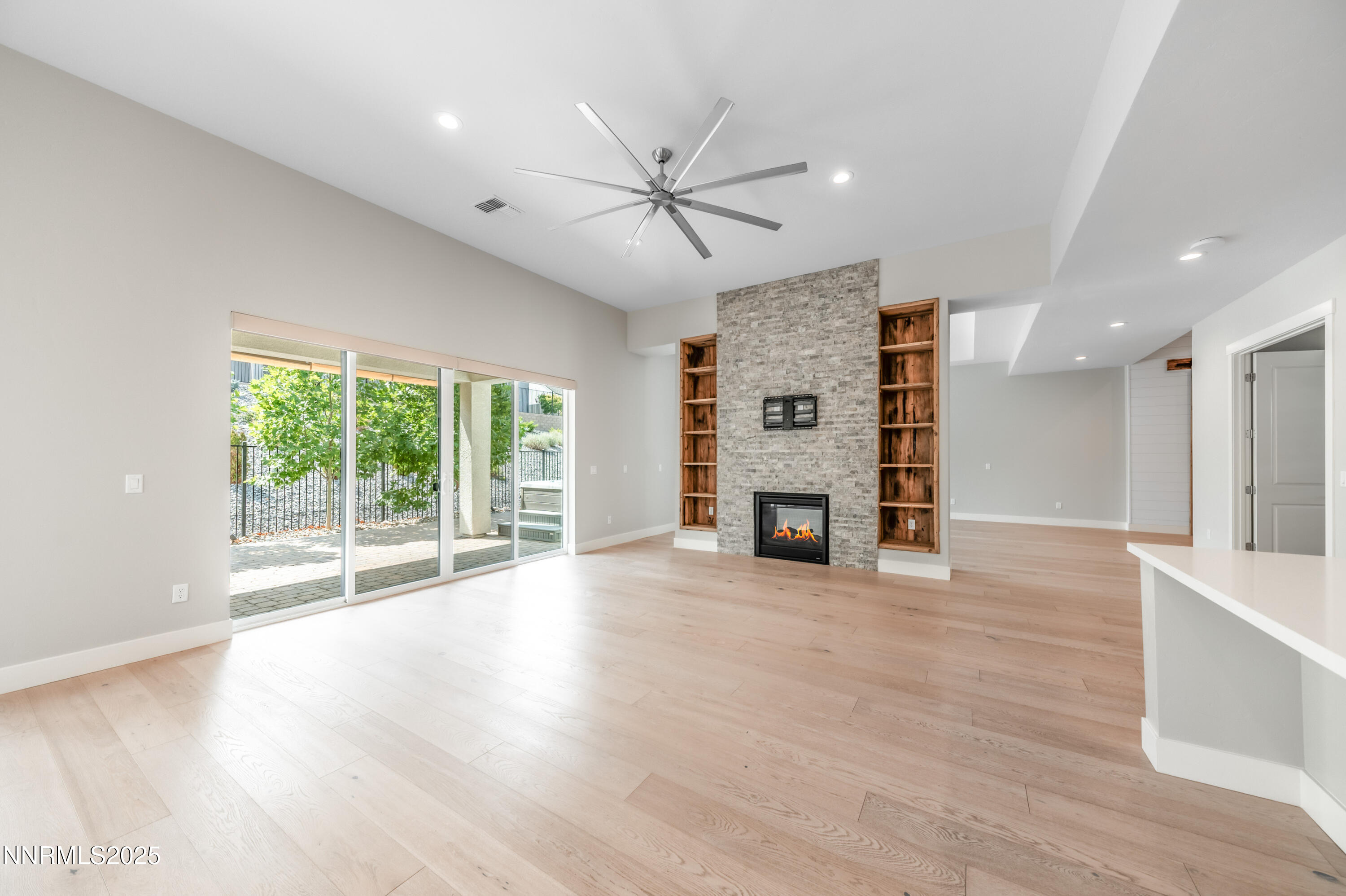 3034 Copper Stone Drive Reno, NV 89521 - Photo 12 of 24 a view of a livingroom with a fireplace a ceiling fan and wooden floor