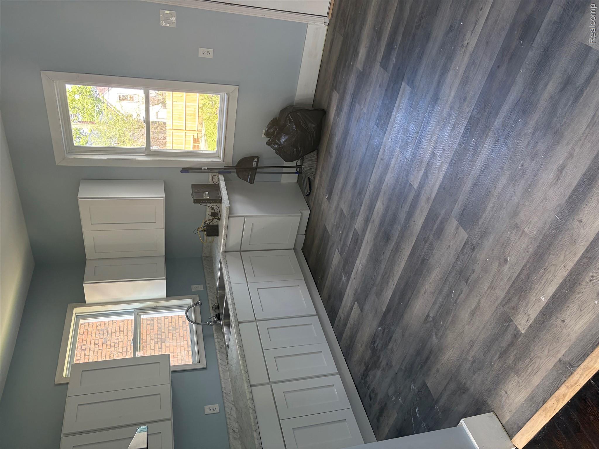 2420 Field Street Detroit, MI 48214 - Photo 6 of 15 Kitchen with white cabinetry, dark wood-type flooring, and extractor fan
