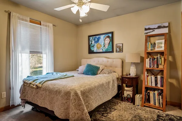 a bedroom with a bed a dresser and a book shelf