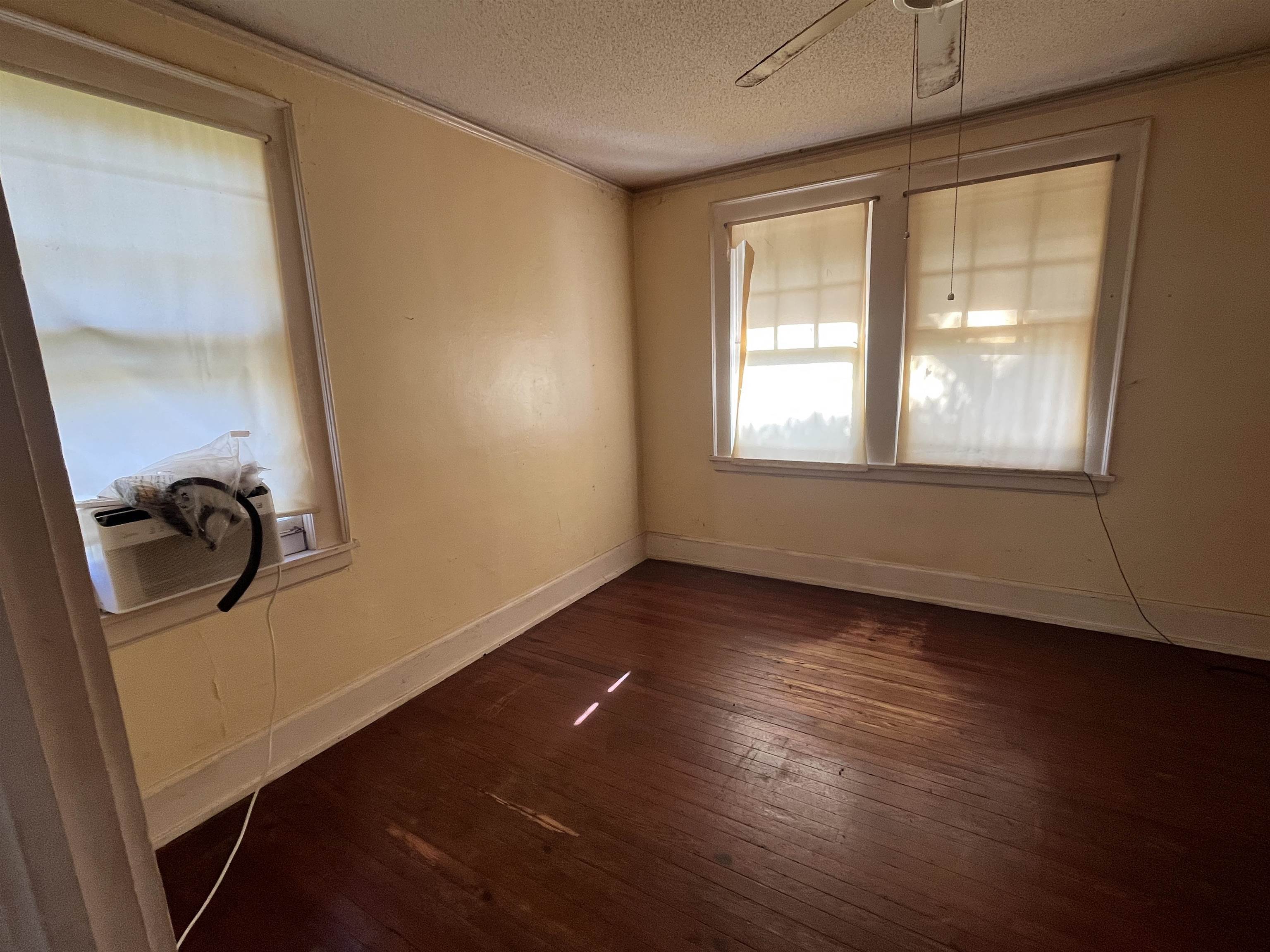 211 4th Street Mobile, AL 36611 - Photo 26 of 34 Unfurnished dining area featuring dark wood finished floors, cooling unit, a textured ceiling, and ceiling fan