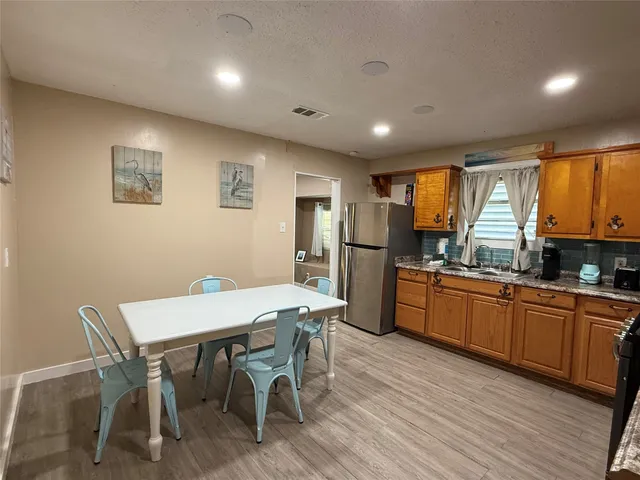 a kitchen with granite countertop cabinets stainless steel appliances with chair and table in it