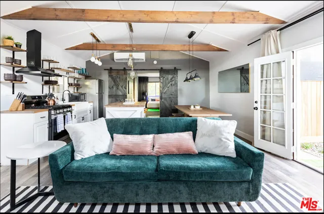 a view of living room kitchen with stainless steel appliances granite countertop dining table and chairs