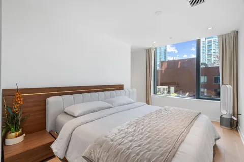 a bedroom with a bed and a large window