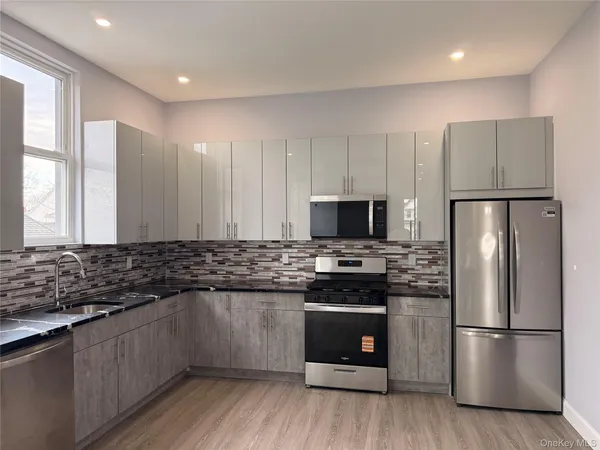 a kitchen with stainless steel appliances a refrigerator a stove a sink and a microwave