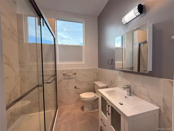 a bathroom with a sink a toilet and shower