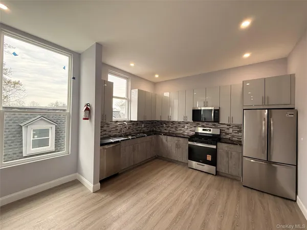 a kitchen with stainless steel appliances granite countertop a refrigerator a stove a sink and a microwave