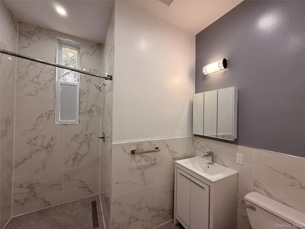 a bathroom with a sink and mirror with toilet