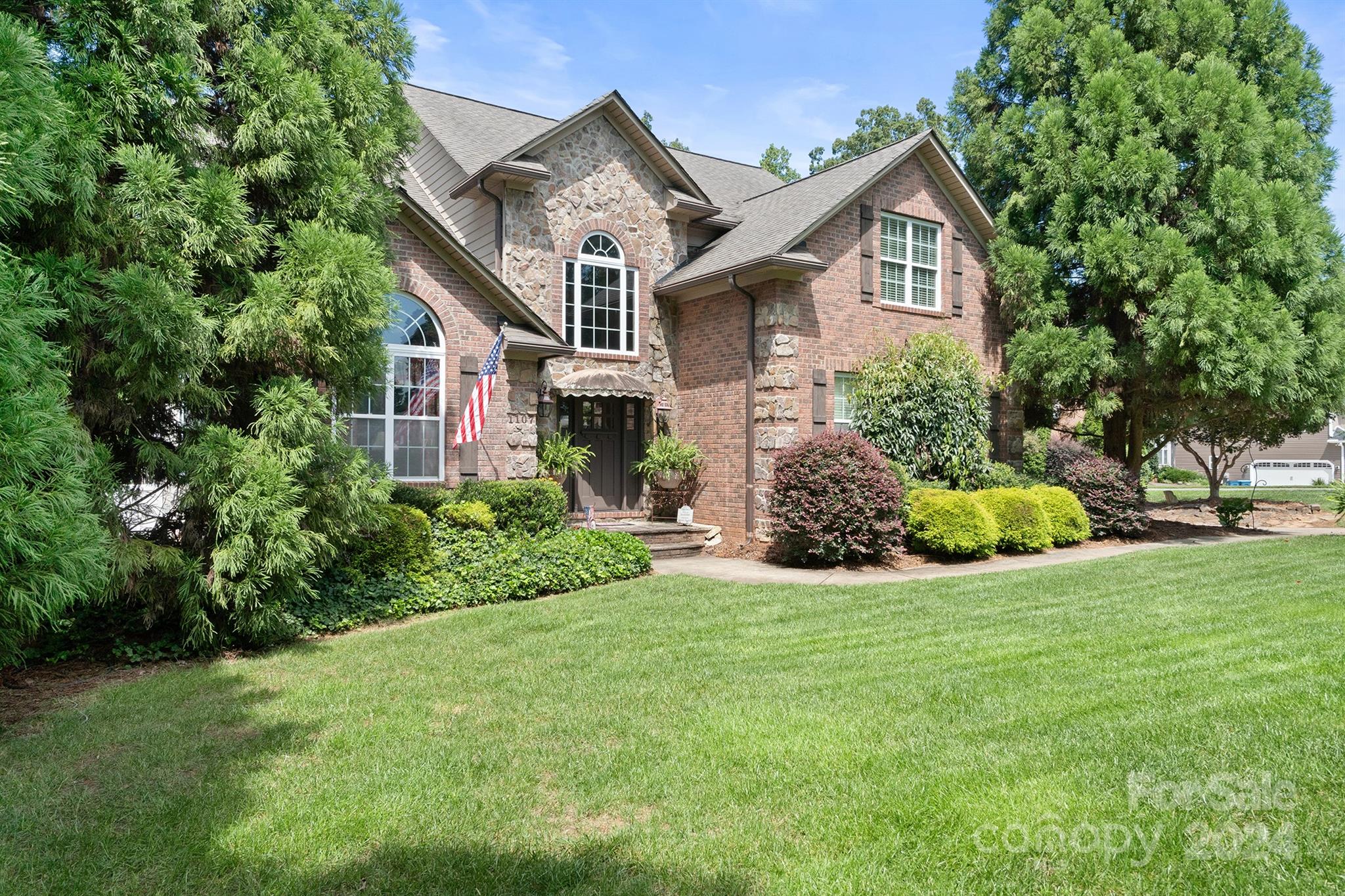 a front view of a house with a yard and trees