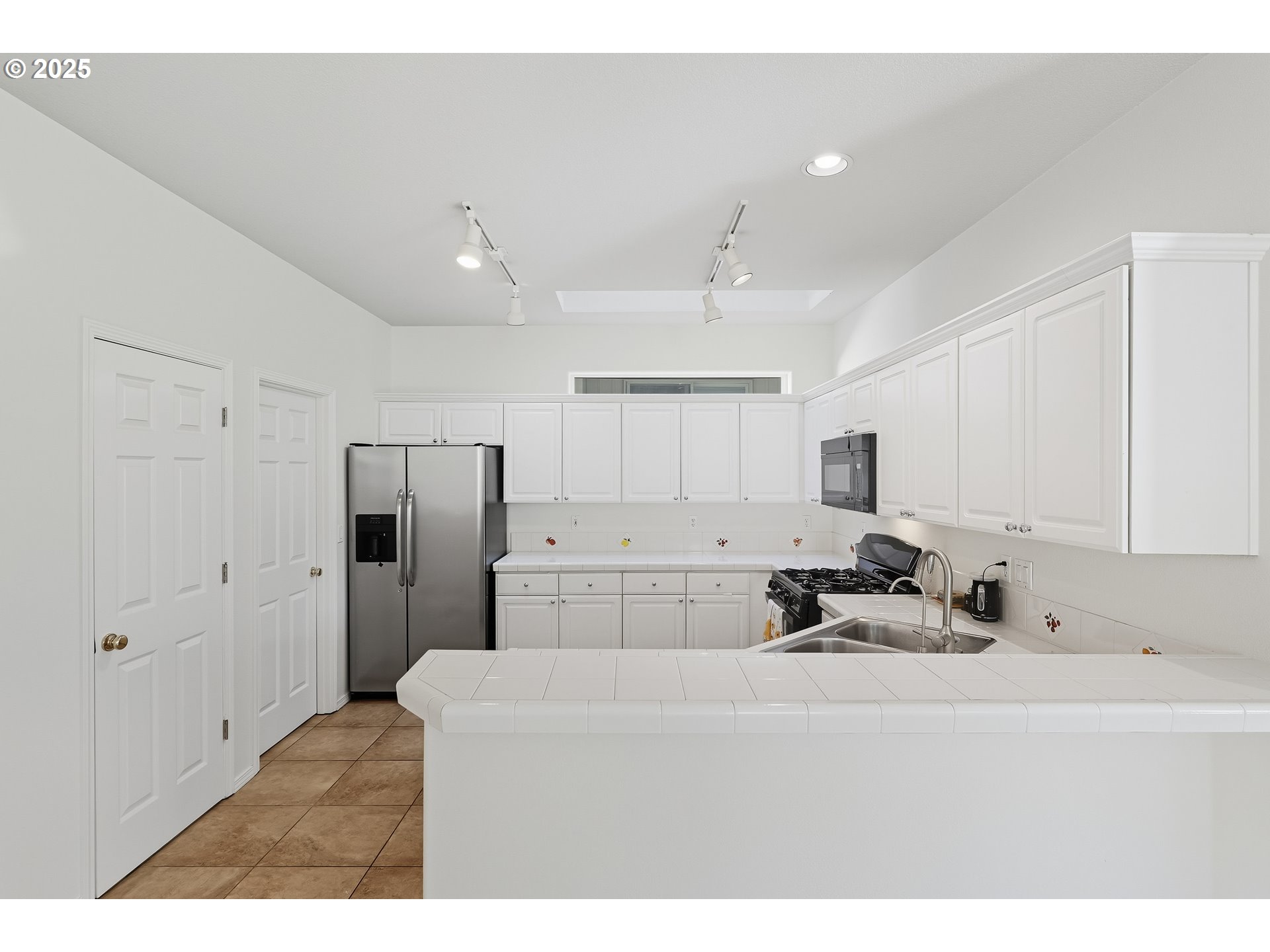 27129 Southwest Aden Avenue Wilsonville, OR 97070 - Photo 11 of 31 a kitchen with stainless steel appliances cabinets a sink and a refrigerator