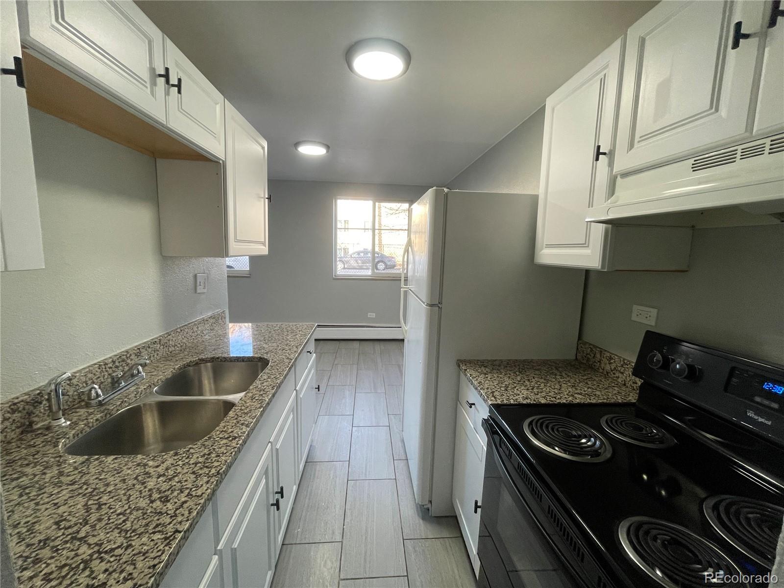 1590 Clinton Street, Unit 2 Aurora, CO 80010 - Photo 2 of 10 a kitchen that has a sink and a stove