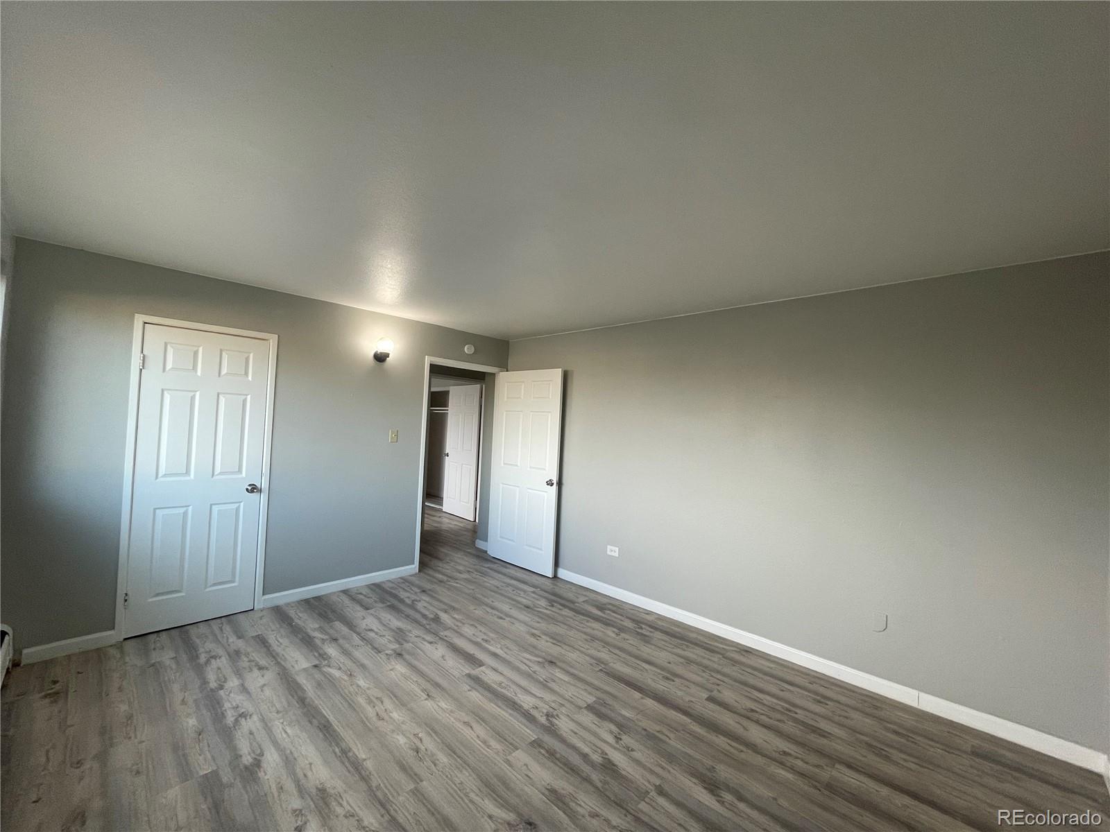 1590 Clinton Street, Unit 2 Aurora, CO 80010 - Photo 9 of 10 an empty room with wooden floor and windows