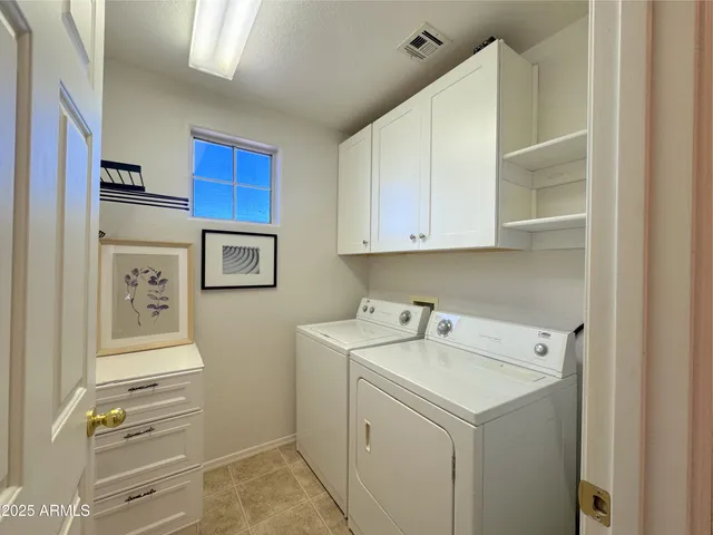 a utility room with cabinets washer and dryer
