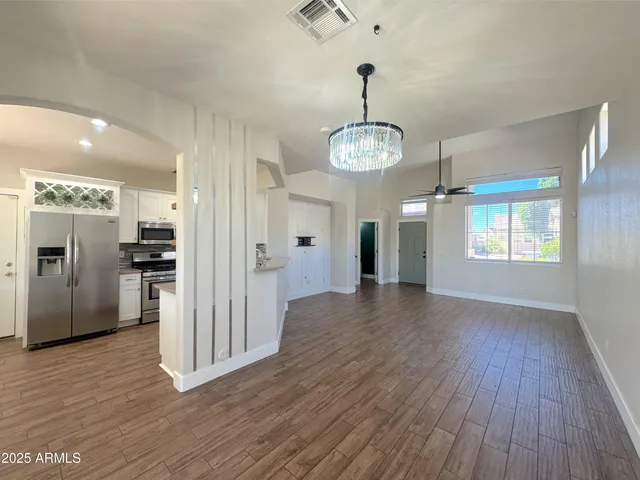 a view of a kitchen with refrigerator and wooden floor
