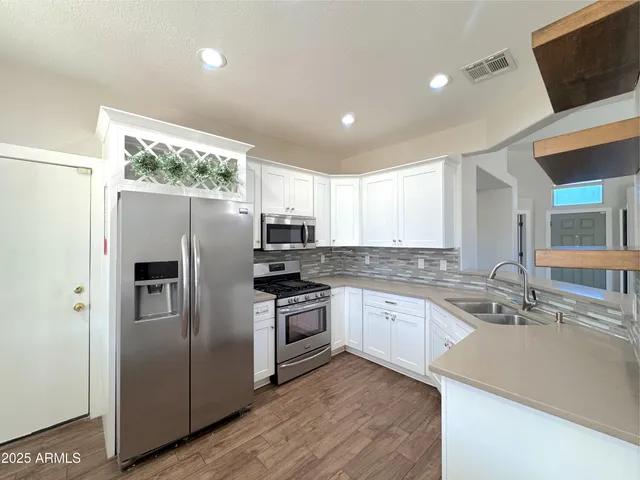a kitchen with stainless steel appliances granite countertop a refrigerator and a sink