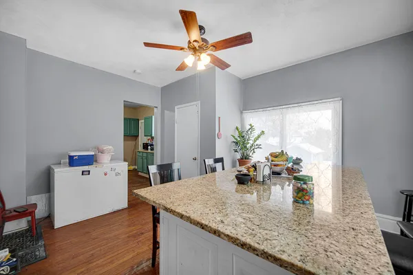 a room with kitchen island a wooden floor and a dining table
