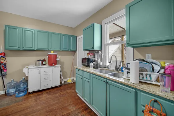 a kitchen with sink a microwave and cabinets