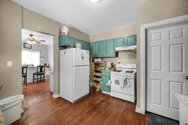 a kitchen with a refrigerator and a stove top oven
