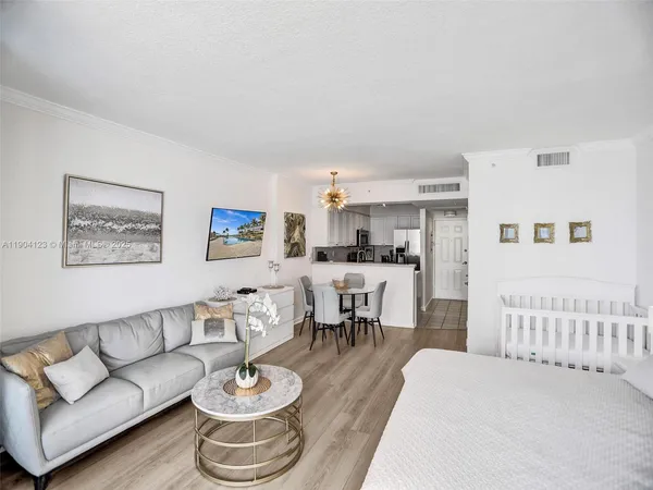 a living room with furniture and a dining table with kitchen view