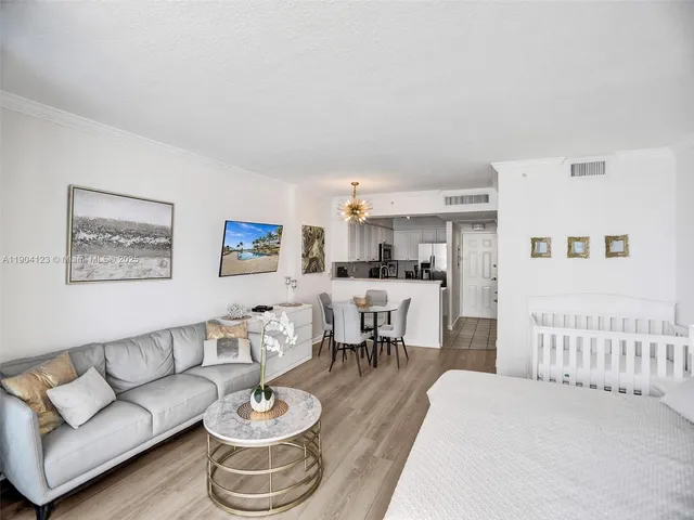 a living room with furniture and a dining table with kitchen view