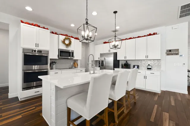 a large white kitchen with lots of counter space and appliances