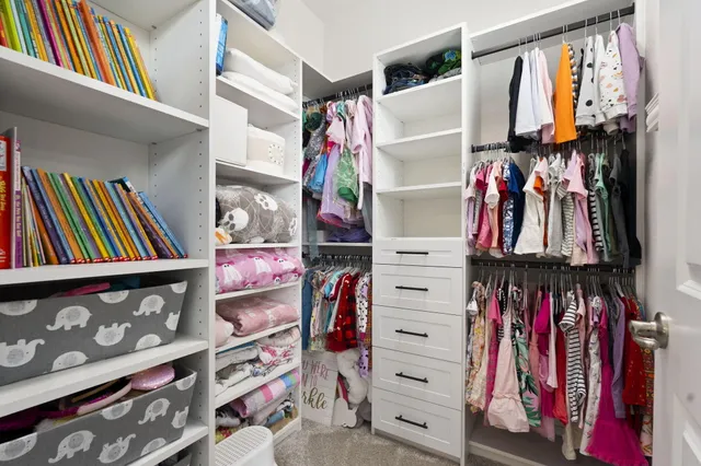 a view of walk in closet with clothes and shoes