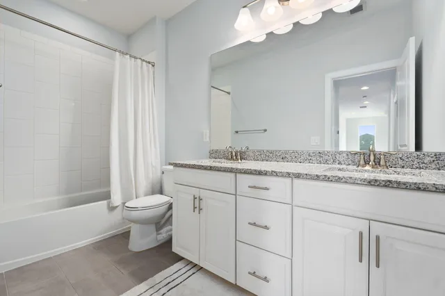 a bathroom with a granite countertop sink a toilet and bathtub