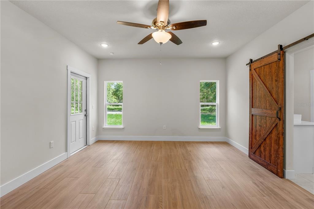 2066 Northwest 79th Loop Ocala, FL 34475 - Photo 12 of 15 an empty room with wooden floor fan and windows