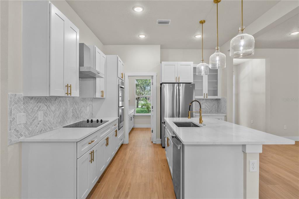 2066 Northwest 79th Loop Ocala, FL 34475 - Photo 4 of 15 a kitchen with stainless steel appliances granite countertop a sink stove and refrigerator