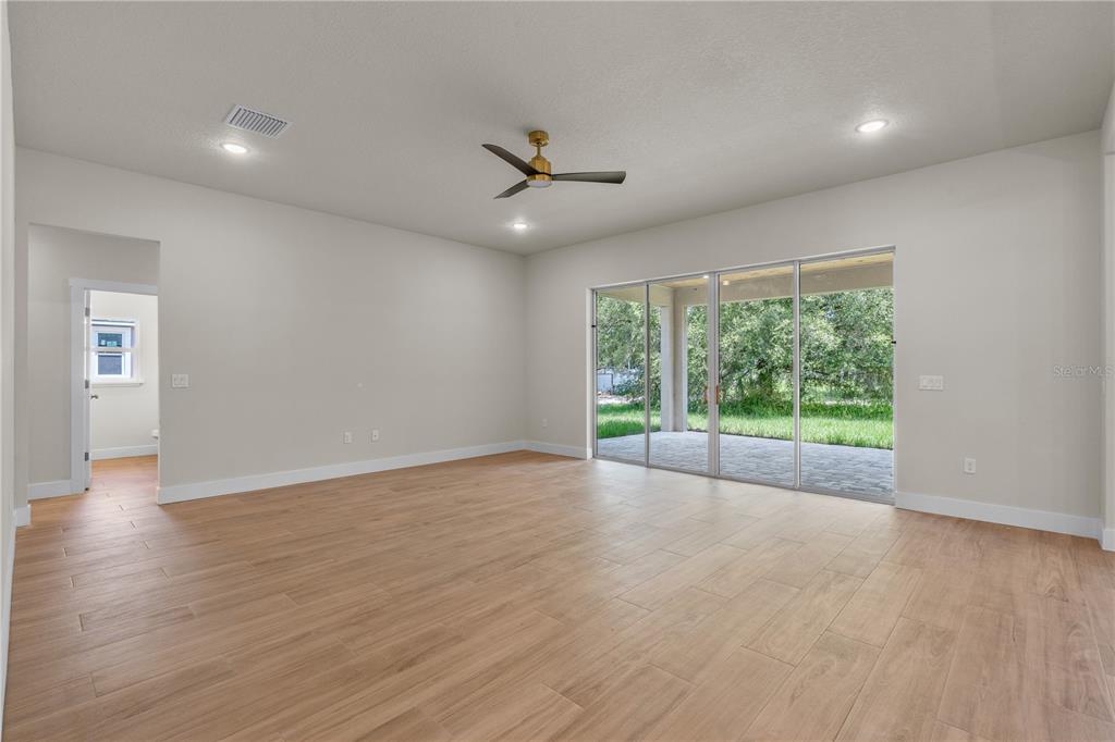2066 Northwest 79th Loop Ocala, FL 34475 - Photo 8 of 15 a view of empty room with wooden floor and fan
