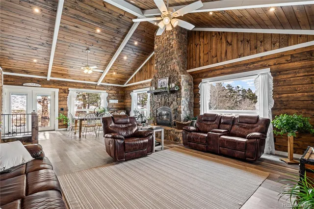 a living room with furniture a fireplace and lots of windows