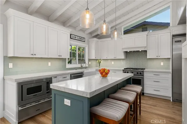 a kitchen with stainless steel appliances a stove a sink and cabinets