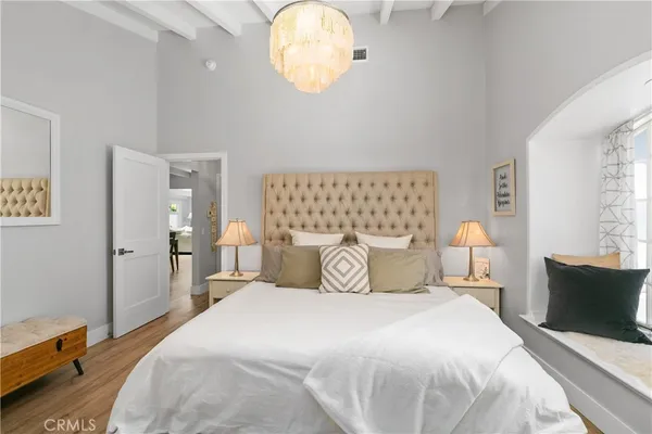 a bedroom with a bed and a chandelier