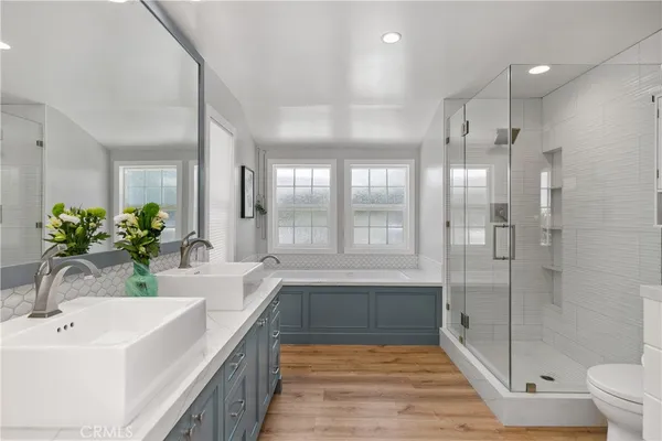 a bathroom with a sink a toilet a large mirror and shower