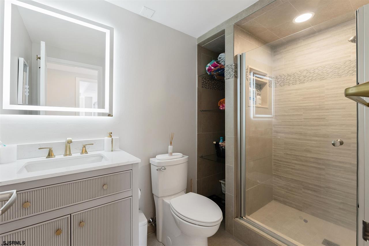 9100 Beach 304, Unit 304 Margate City, NJ 08402 - Photo 14 of 25 a bathroom with a sink a toilet and shower