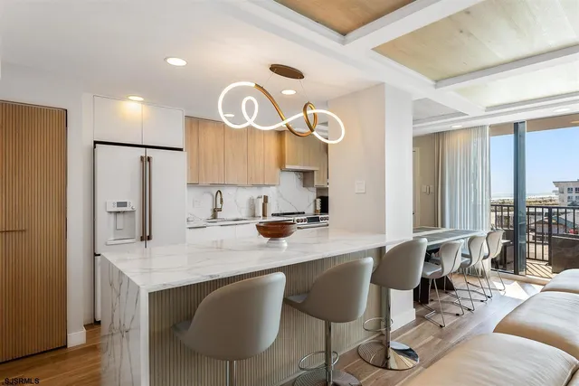 a kitchen with granite countertop a table chairs stove a sink and dishwasher