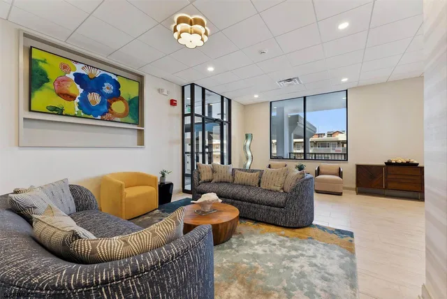 a living room with furniture a couch and a bookshelf with wooden floor
