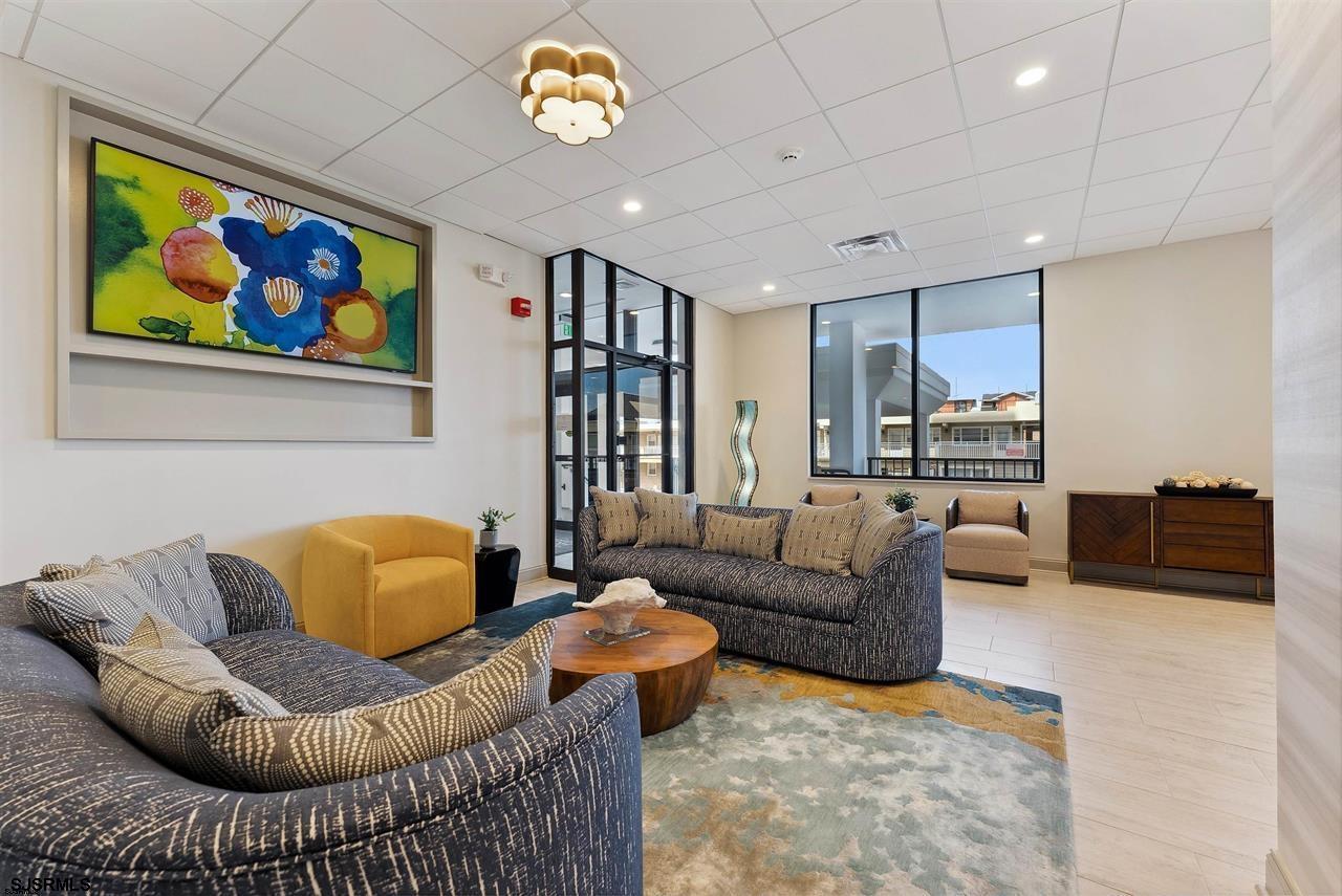 9100 Beach 304, Unit 304 Margate City, NJ 08402 - Photo 21 of 25 a living room with furniture a couch and a bookshelf with wooden floor