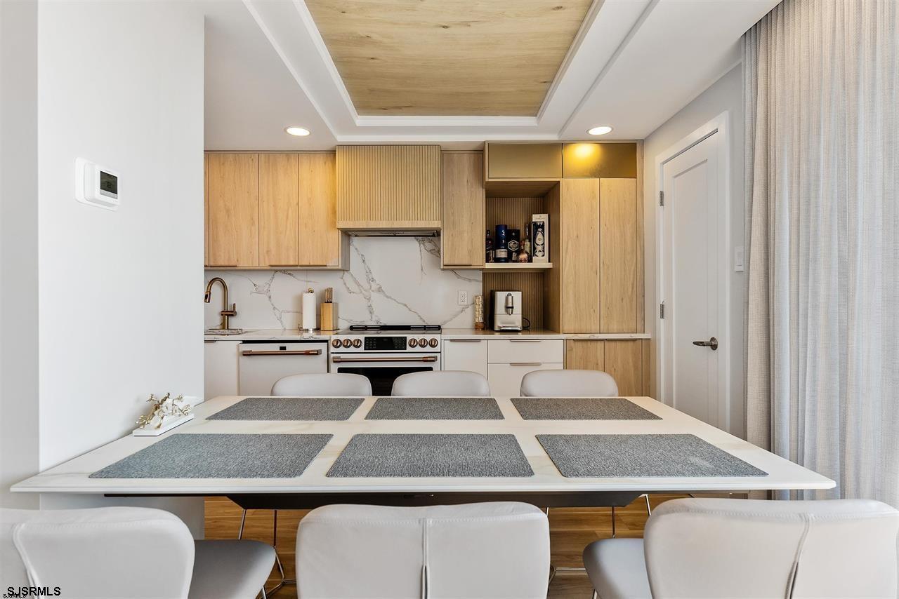 9100 Beach 304, Unit 304 Margate City, NJ 08402 - Photo 8 of 25 a kitchen with a table chairs and a refrigerator