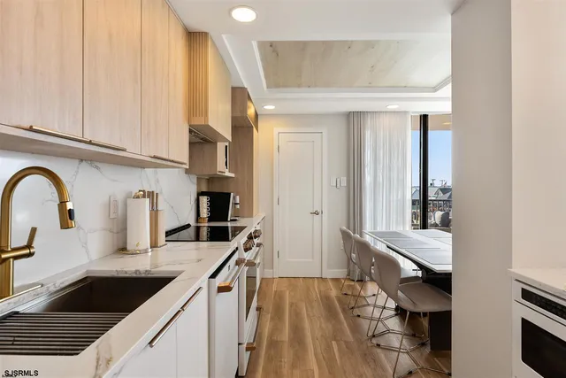 a kitchen with granite countertop a stove and white cabinets