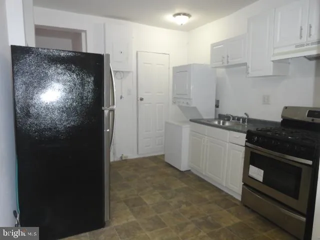 a kitchen with stainless steel appliances granite countertop a refrigerator and a stove