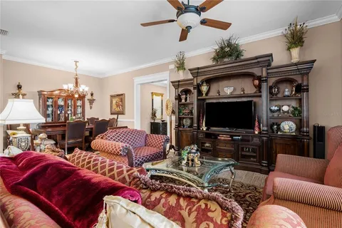 a living room with furniture a ceiling fan and a flat screen tv