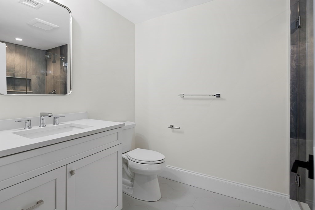 28 Hillside Avenue Needham, MA 02494 - Photo 25 of 32 a bathroom with a toilet a sink and mirror